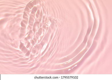 Closeup pink transparent clear calm water surface texture and splashes   bubbles  Trendy abstract summer nature background  Coral colored waves in sunlight 