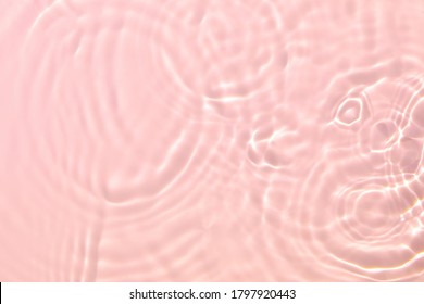 Cierre de la textura transparente rosa transparente transparente de la superficie del agua con salpicaduras y burbujas  Fondo natural de verano abstracto y moderno  Olas de color coral la luz del sol 