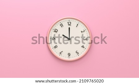 Closeup pink wall clock set on pastel pink background.  White wall clock hanging on the wall. Minimalist flat lay image of plastic wall clock over pink background. Copy space and central composition.