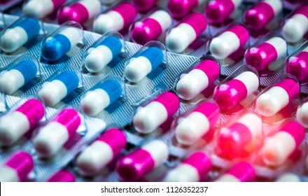 Closeup pink-white and blue-white antibiotics capsule pills in blister pack. Antimicrobial drug resistance. Pharmaceutical industry. Global healthcare. Pharmacy background. Amoxicillin capsule pills. 