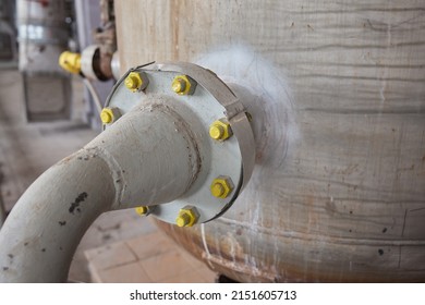 Close-up at pipeline valve which is using to control production process in the oil refinery plant. Selective focus at the valve handle wheel, Heavy industrial object photo.