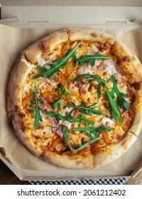 Close-up Of Pizza With Bacon In A Disposable Dish. Top View Of Takeaway Food In A Fast Food Cafe. On Photo - Mozzarella Cheese, Tomatoes, And Red Basil. The Classic Recipe. Food For Family And Friends