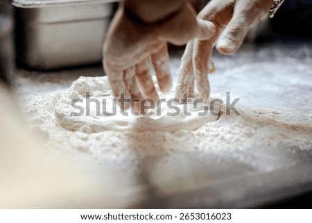 Close-up of a pizza maker preparing a pizza