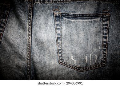 Close-up of a plain back pocket of a pair of well-worn and tattered jeans.