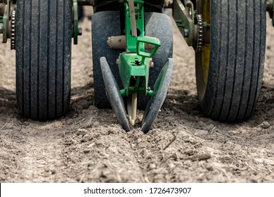 Closeup Of Planter In Farm Field Planting Corn Seed In Dry, Dusty Soil During Spring Season