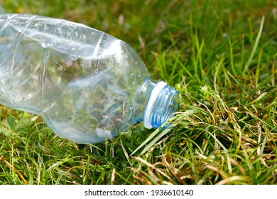 Close-up of plastic bottle on green lawn. Global warming, recycling plastic, plastic free. Plastic Environmental pollution. 