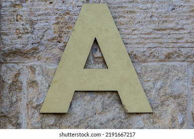 Close-up of the plastic letter A hanging on the building to inform residents about the entrance number. Letters denoting parts of a residential building.