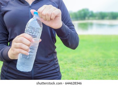 Close-up Plastic Water Bottle In Woman Hand After Exercise