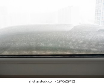 Close-up Of A Plastic Window In The House. There's A Lot Of Snow On The Back Side. The Concept Of A Snow Storm, Inclement Weather, Winter