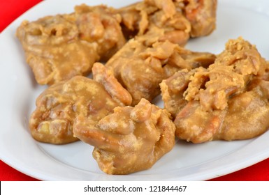 Closeup Of Platter Of Pecan Pralines In Selective Focus Against Red Background