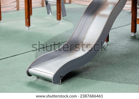closeup playground slider for children play sliding down to the safety soft rubber stone floor.