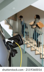 Close-up Of Plugged Cable Charging An Electric Family Car In A Particular Garage