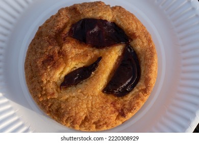 Close-up Of A Plum Polenta Cake Served On A White Paper Plate. View From Above.