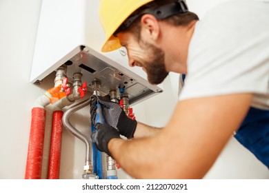 Closeup Of Plumber Using Screwdriver While Fixing Boiler Or Water Heater, Working On Heating System In Apartment