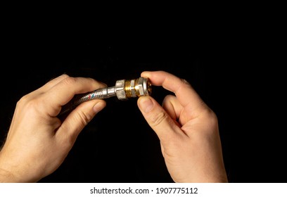 Close-up Of A Plumber's Hand Connect A Brass Fitting And A High Pressure Plumbing Hose