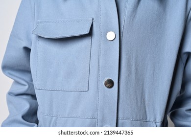 Close-up: a pocket on a denim jacket, overalls, a fragment of a photograph of a girl in a light blue jacket with a patch pocket.