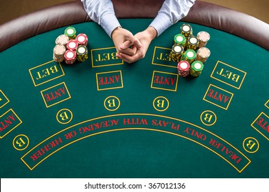 Closeup of poker player with chips at green casino table