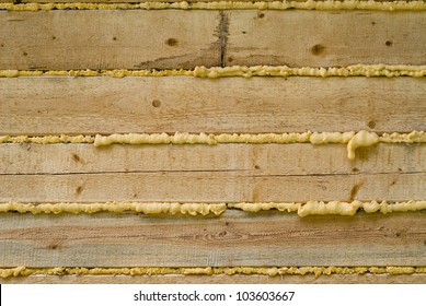 Close-up of Polyurethane foam filling gap in wooden construction, background
