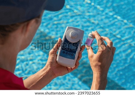 Close-up of a pool technician checking water pH level with a digital meter