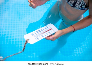 Closeup Pool Water Thermometer in  Female hand checking the temperature warmth 
