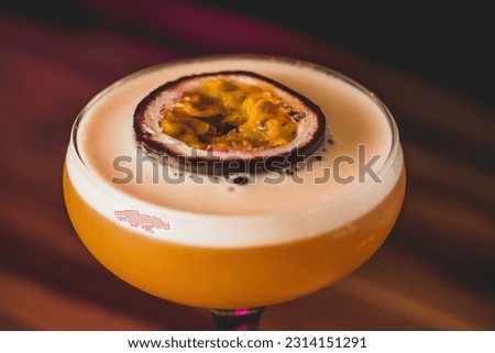 A closeup of a pornstar martini cocktail with a passion fruit