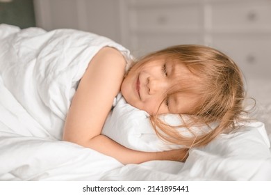 Close-up portrait of adorable child sleeping in the bed. Adorable little girl is sleeping in the bed