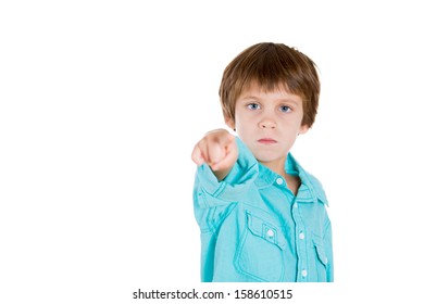 Closeup Portrait Of Adorable Serious Kid Pointing At You Or Camera Gesture, Isolated On White Background With Copy Space