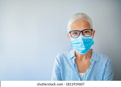 Closeup up portrait of adult woman wearing medical mask indoors. Looking at camera. Virus concept. Portrait of woman wearing face mask during Covid-19 pandemic outbreak - Powered by Shutterstock