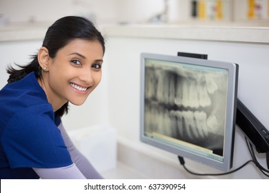 Closeup Portrait Of Allied Health Dental Professional In Blue Scrubs Examining Dental X-ray On Computer Screen, Isolated Dentist Office