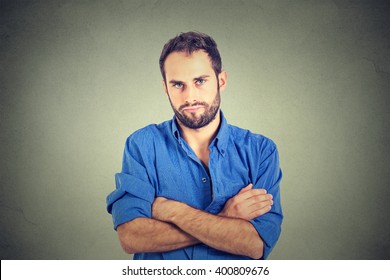 Closeup Portrait Of Angry Grumpy Young Man Looking Very Displeased Isolated On Gray Wall Background. Negative Human Emotions Facial Expression Feelings Attitude