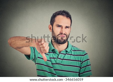 Closeup portrait angry, unhappy, young man showing thumbs down sign, in disapproval of offer situation isolated on gray background. Negative human emotions, facial feelings Foto stock © 