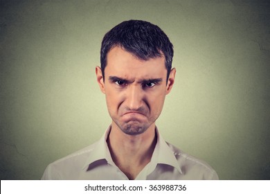Closeup portrait of angry young man about to have nervous atomic breakdown isolated on gray background. Negative human emotions facial expression feelings attitude