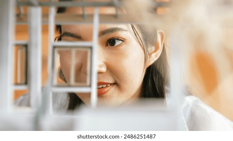 Closeup portrait of architect engineer face reviewing house model while inspect building construction. Project manager checking house model. Business design concept. Focus on face. Manipulator. - Powered by Shutterstock