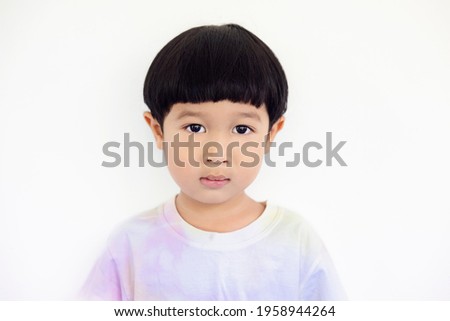 Close-up portrait Asian kids, Caucasian boy little child standing wearing a tie-dye shirt smiling at the camera on white background.