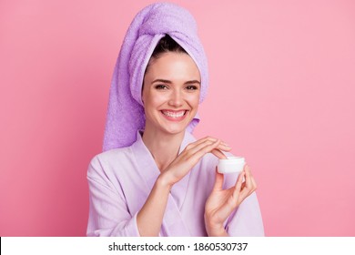 Close-up portrait of attractive cheerful mature girl wearing turban on head using smoothing cream isolated on pink pastel color background - Powered by Shutterstock