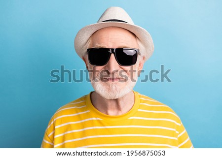 Close-up portrait of attractive cool man wearing black sun specs isolated over bright blue color background