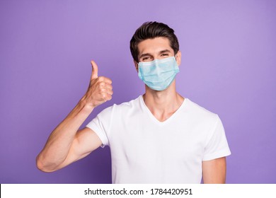 Close-up portrait of attractive healthy guy wearing safety gauze mask showing thumbup influenza preventive measures isolated bright vivid shine vibrant lilac violet purple color background - Shutterstock ID 1784420951