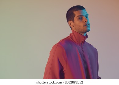 Close-up Portrait Of Attractive Male Model. Retro Wave Portrait Of A Young Man At Studio. High Fashion Male Model In Colorful Bright Neon Lights