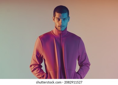 Close-up Portrait Of Attractive Male Model. Retro Wave Portrait Of A Young Man At Studio. High Fashion Male Model In Colorful Bright Neon Lights