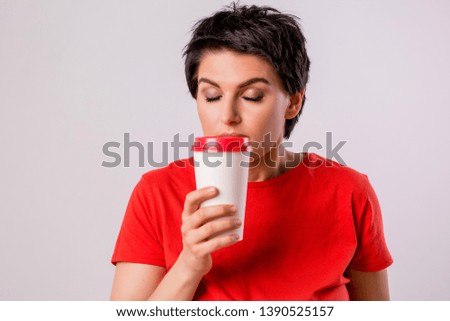 Close-up portrait of attractive pretty cute stylish cute cute cute funny brunette in everyday red t-shirt holding looking at paper Cup of coffee isolated on white background,concept of love for coffe
