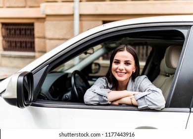 Closeup portrait attractive woman buyer sitting in her new car excited ready for trip isolated outside dealer dealership lot office. Personal transportation auto purchase concept