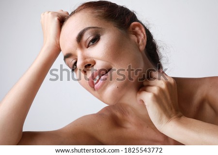 Close-up portrait of attractive woman touching her face, mature beauty concept. Anti-aging treatment.