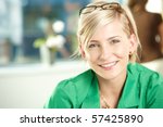 Closeup portrait of attractive young businesswoman wearing green shirt, smiling.