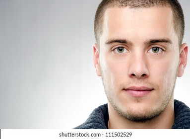 Close-up portrait of attractive young man on gray background with copy space