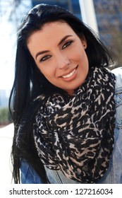 Closeup portrait of attractive young woman wearing scarf, smiling.