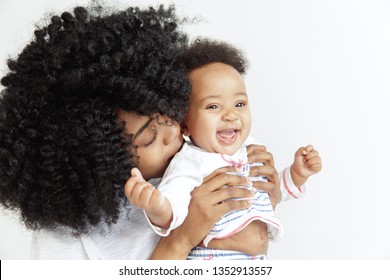 Closeup portrait of beautiful african woman holding on hands her little daughter on white background. Family, love, lifestyle, motherhood and tender moments concepts. Mother's day concept or