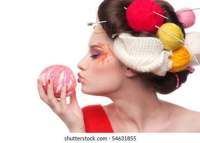 Closeup portrait of beautiful fashion woman with color face art. All in knitting style. Wool balls. Kiss