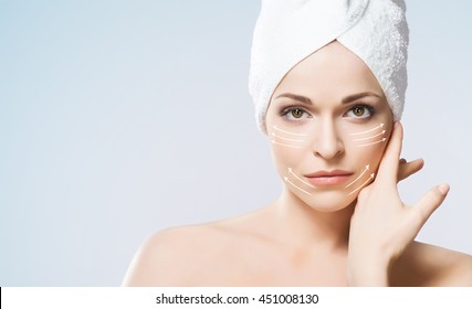 Close-up portrait of beautiful, fresh, healthy and sensual girl with arrows on her face. Medicine, spa and skin care concept.