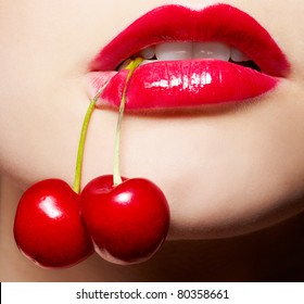 close-up portrait of beautiful girl's lower part of face with two red cherries in mouth