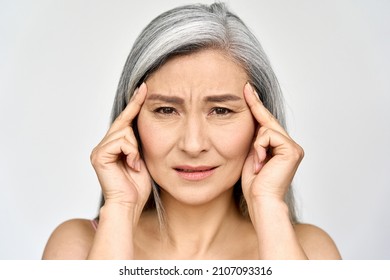 Closeup Portrait Of Beautiful Mature Old Senior Mid Aged Asian Ethnicity Woman Suffering From Headache Migraine Massaging Temples In Menopause Period Illness, Worried Having High Blood Pressure.